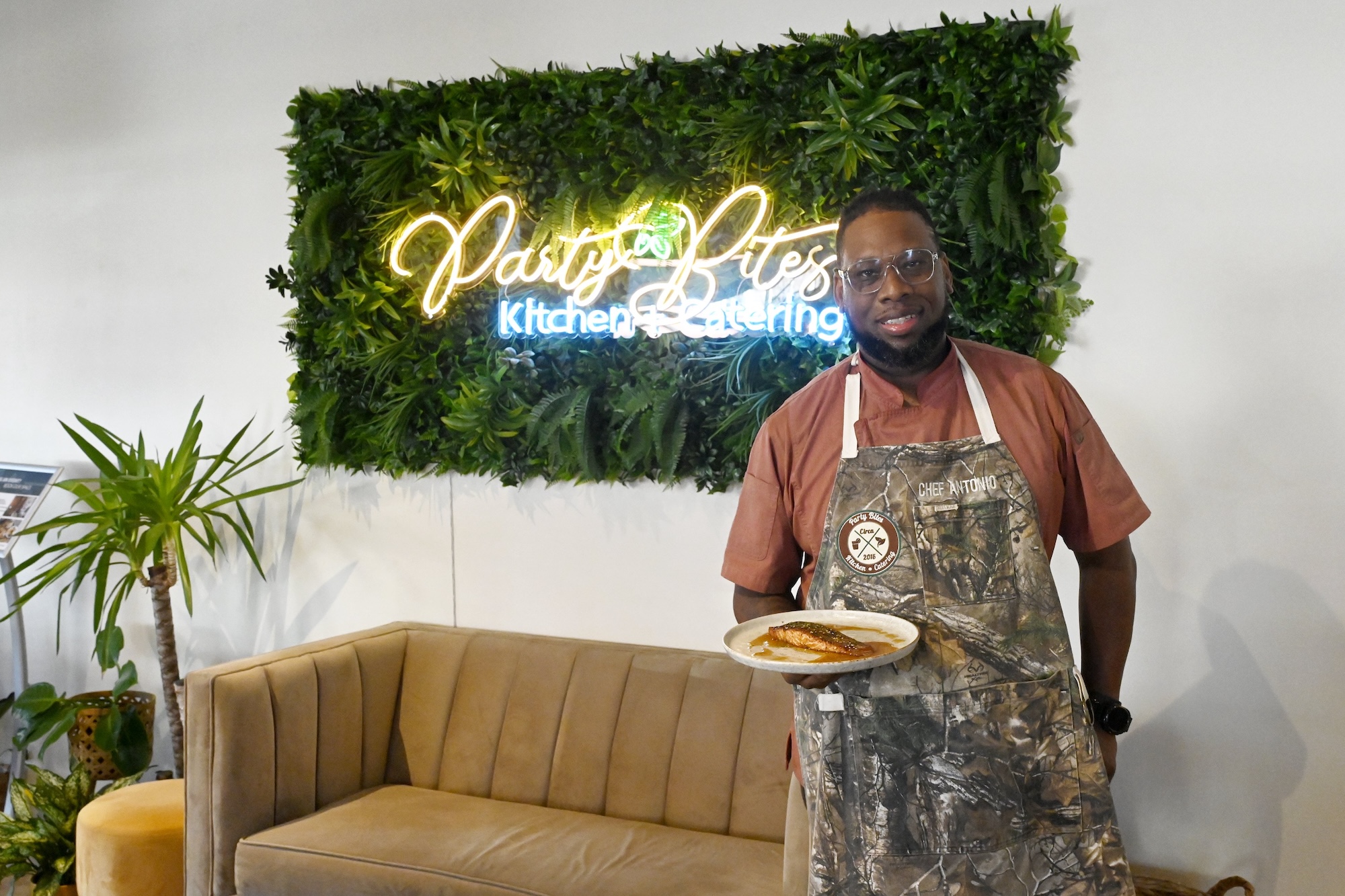 Staff photo by Abby White / Chef Antonio Tate poses for a portrait with his signature Chai Bourbon glaze to a salmon filet. Chef Antonio Tate is the owner/ head chef for Party Bites, a Chattanooga catering business.