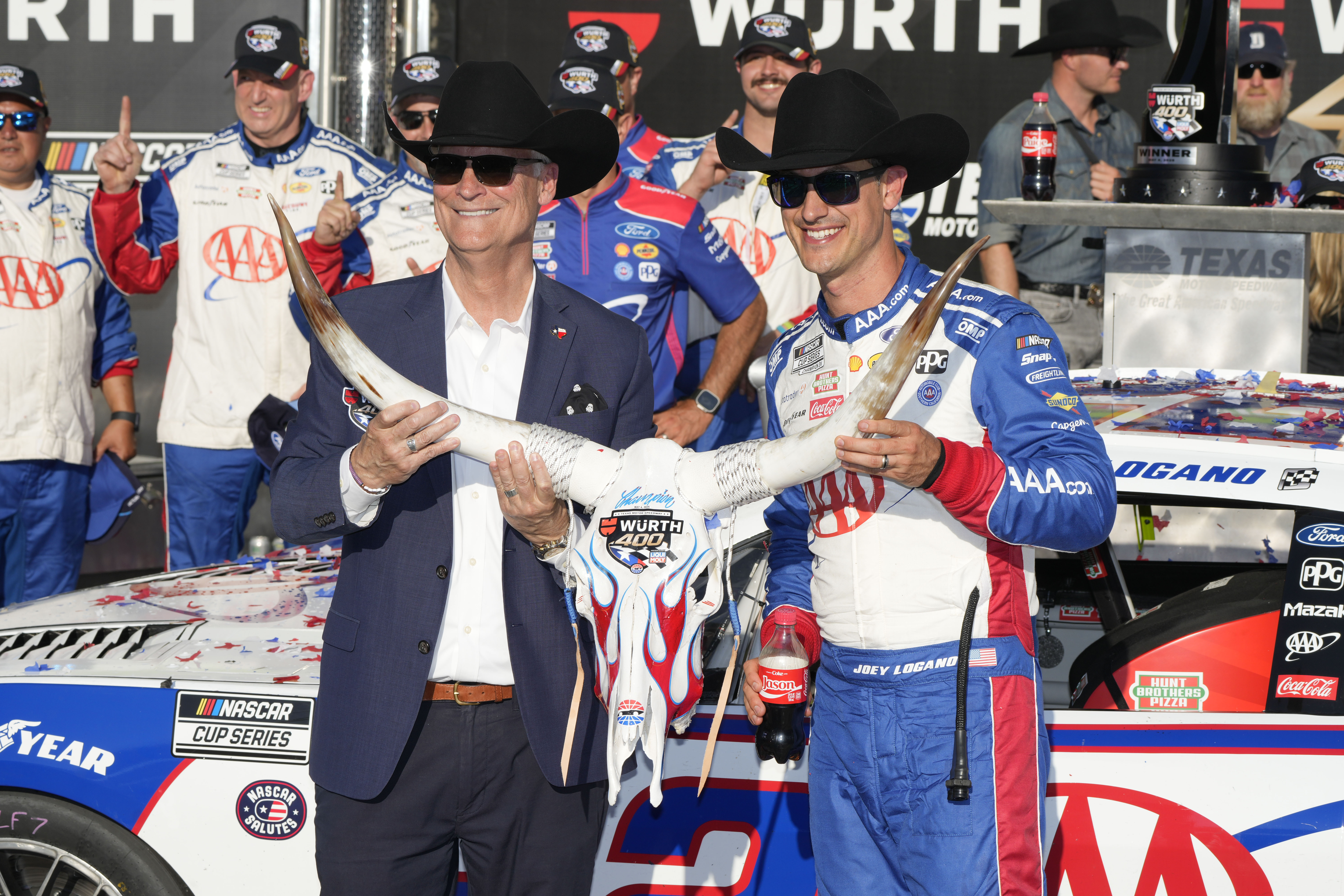 Joey Logano, right, poses with a cow skull Wurth 400 trophy in Victory Lane tafter winning a NASCAR Cup Series auto race at Texas Motor Speedway in Fort Worth, Texas, Sunday, May 4, 2025. (AP Photo/Gareth Patterson)