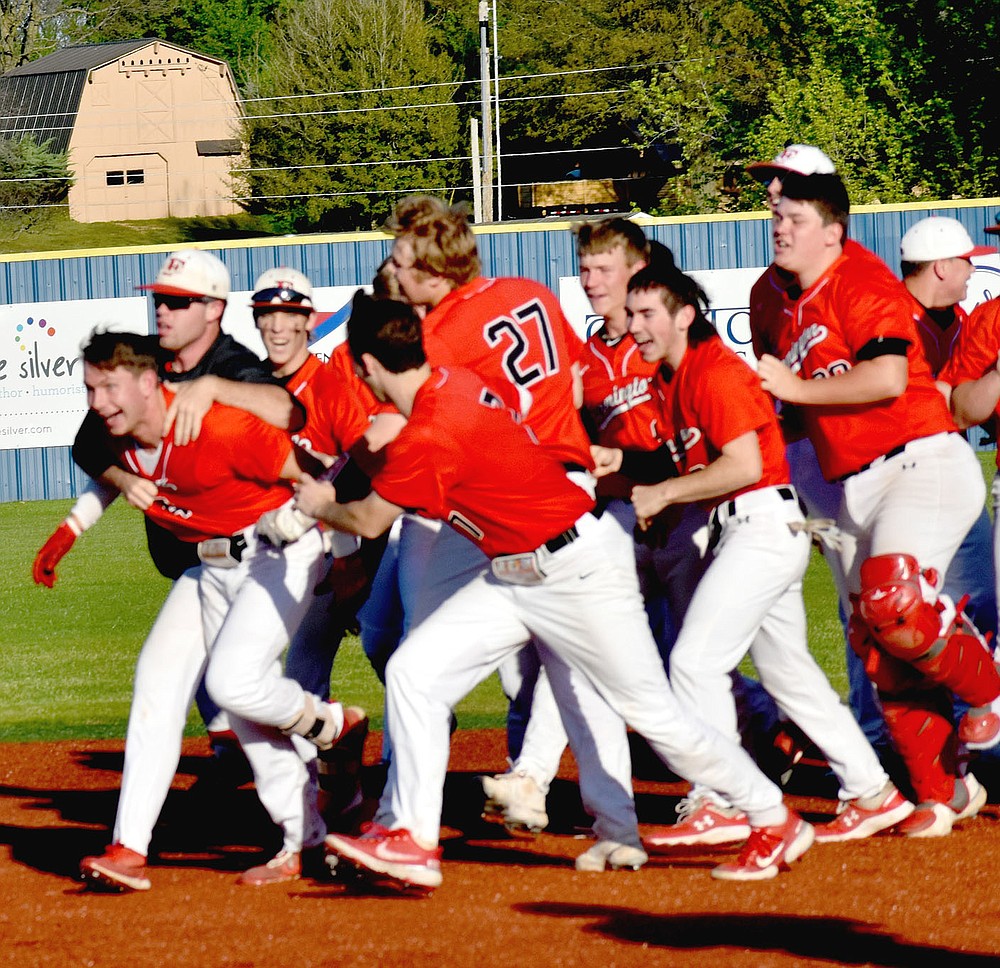 MARK HUMPHREY ENTERPRISE-LEADER/Farmington teammates mob Michael White, who was hit by a pitch with the base loaded walking in the winning run during a 5-4 extra innings game won by the Cardinals over Huntsville in the District 4A-1 baseball tournament on April 30 at Shiloh Christian's field in Springdale.