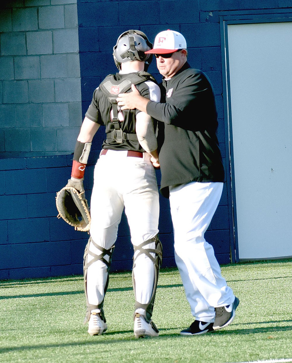 MARK HUMPHREY ENTERPRISE-LEADER/Farmington veteran baseball coach Jay Harper (left) consoles Huntsville's catcher moments after the Eagles gave up the winning run when Farmington's Michael White was hit by a pitch with the bases loaded in the bottom of the ninth inning to conclude a down-to-the-wire District 4A-1 baseball tournament game at Shiloh Christian's field in Springdale on April 30. Farmington won 5-4 to advance into the tournament championship.