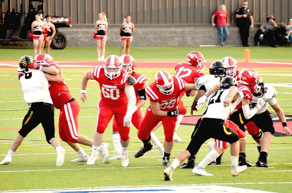 MARK HUMPHREY ENTERPRISE-LEADER/Farmington's offensive line creates a wall during a running play. The Cardinals throttled rival Prairie Grove, 56-27, in the annual "Battle of 62" football contest played Friday before a packed house at Cardinal Stadium.