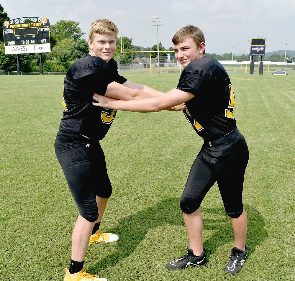 MARK HUMPHREY ENTERPRISE-LEADER/Prairie Grove teammates Kaden Rochier (left), 5 feet 11, 184 pounds, who plays right guard for the Junior Tigers, contends with Morgan Cobb, 5 feet 10, 150 pounds, who plays linebacker during a media day football photo shoot on Aug. 4. By the time Thursday rolled around the Junior Tigers were weary of banging on each other in practice and more then willing to tango with their U.S. 62 rivals, Farmington.