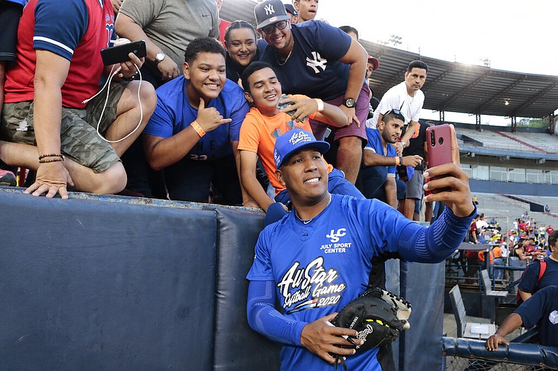 FILE - In this Jan. 11, 2020, file photo, Kansas City Royals' Salvador Perez takes a photograph with a fan's cellphone prior to an All-Star exhibition softball game at Rod Carew stadium in Panama City, Panama. When the virus wanes enough to allow the games to begin again, the very essence of these events will likely be missing. 
“You know how much I love to talk to the fans, you know? To be in conversation, to throw the ball to kids,” Kansas City Royals catcher Salvador Perez said. (AP Photo/Eric Batista, File)