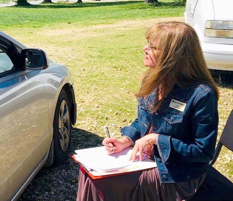 Photo submitted
Caseworker Lisa Burch interviews a client outside the Genesis House. The organization closed its building and met with clients in the parking lot instead because of the covid-19 pandemic. On Monday, the nonprofit began modified onsite operations, with the building still off limits to guests.