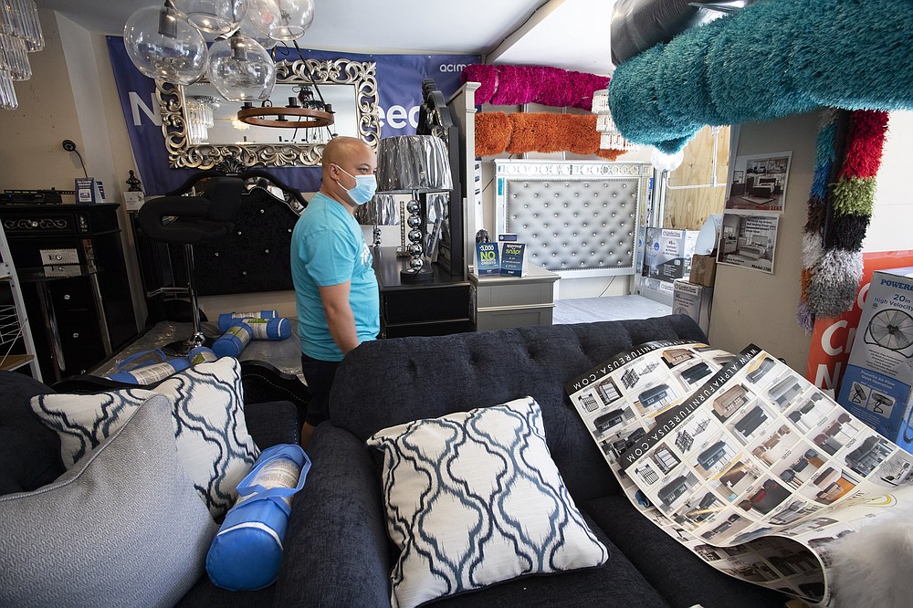 Stanley Castillo, the owner of JD Concourse Furniture, walks through his Bronx store, Monday, June 8, 2020, in New York. Castillo stood in front of his business a week ago during protests in his neighbourhood to protect it from potential looting. After three bleak months, New York City will try to turn a page when it begins reopening Monday after getting hit first by the coronavirus, then an outpouring of rage over racism and police brutality. (AP Photo/Mark Lennihan)