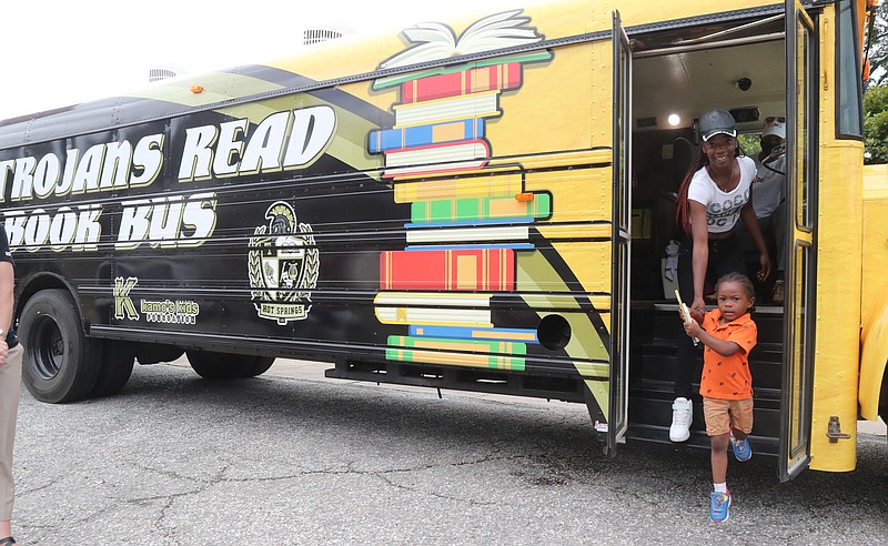 Patrick Crowder, 3, of Hot Springs steps off the TrojansRead Book Bus with the help of his mother Shadreka Robinson at the Family Dollar Store on Park Avenue Tuesday, June 9, 2020. Crowder was the first child to check out books on the district’s new mobile book library. - Photo by Richard Rasmussen of The Sentinel-Record