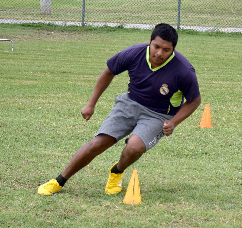 Westside Eagle Observer/MIKE ECKELS

Carlos Hernandez circles around a cone as he finishes a speed drill during the 2020-21 Decatur football light practice session at Bulldog Stadium June 10. The Arkansas Activities Association cleared some high school sport to practice drills during June until mid-July. Coaches and team assistants are required to wear masked and gloves throughout each practice session.