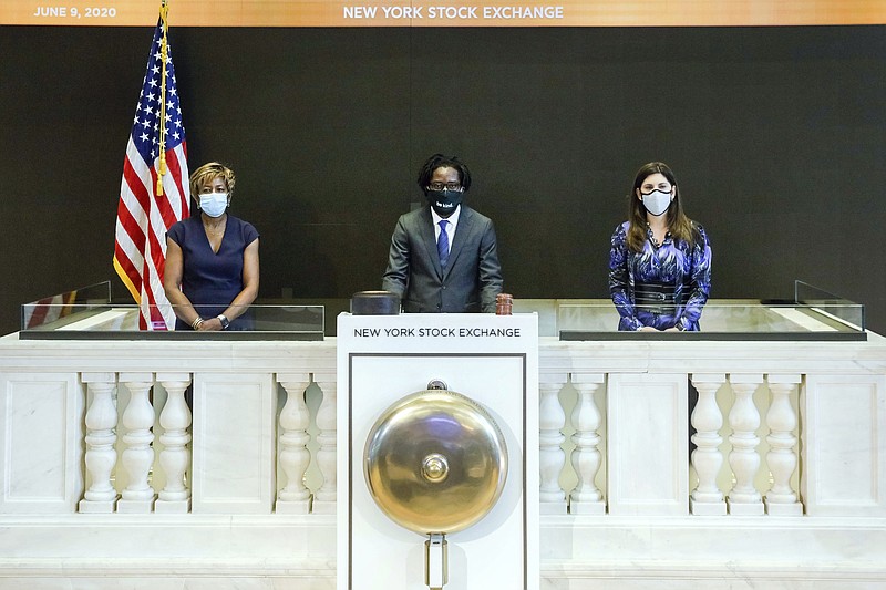 In this photo taken from video provided by the New York Stock Exchange, Frederick Baba, center, managing director Goldman Sachs, accompanied by NYSE President Stacey Cunningham, right, and Intercontinental Exchange Board member Sharon Bowen, rings a single strike of the New York Stock Exchange bell in tribute to the life of George Floyd, initiating eight minutes and forty-six seconds of silence to coincide with the start of Mr. Floyd's funeral, Tuesday June 9, 2020. (New York Stock Exchange via AP)