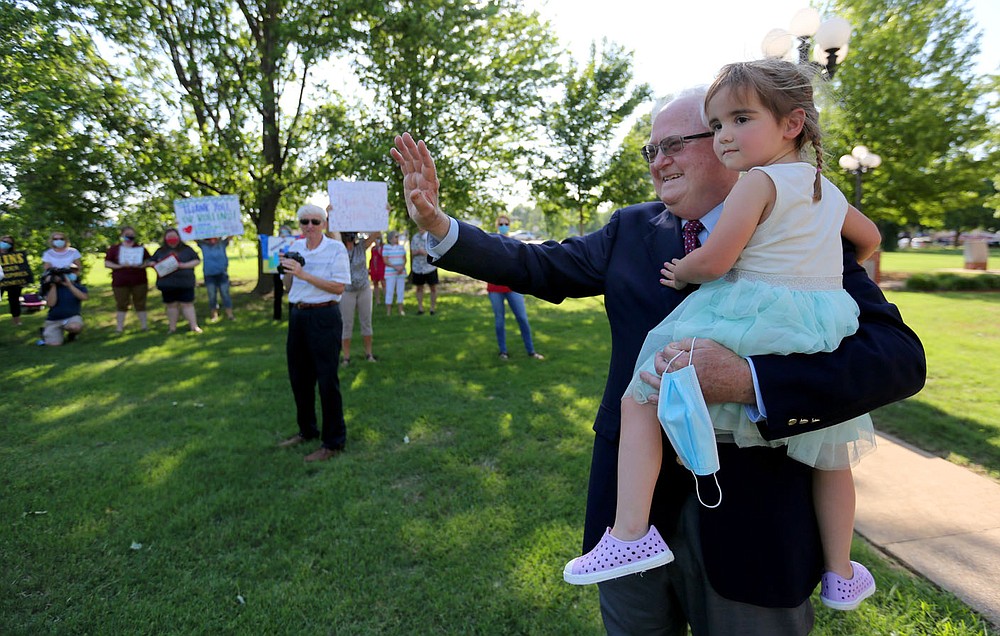 Jim Rollins, superintendent for Springdale Public Schools, holds his granddaughter Adalynn Rollins, 2, as he is greeted by teachers, faculty and well wishers, Tuesday, June 9, 2020, following his last school board meeting in Springdale. Rollins had served as the superintendent for Springdale Public Schools for the last 38 years and has accepted the position as the President of the Northwest Arkansas Technical Institute in Springdale. Visit nwaonline.com/200610Daily/ and nwadg.com/photos for a photo gallery.
(NWA Democrat-Gazette/David Gottschalk)