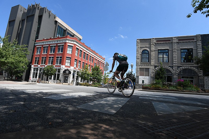 NWA Democrat-Gazette/J.T. WAMPLER A cyclist rides along Center St. in Fayetteville Monday July 1, 2019. As of Monday, Arkansas bicyclists are able to treat stop signs as yields and red lights as stop signs. The law allows cyclists to maintain their momentum and encourages them to ride on back roads.