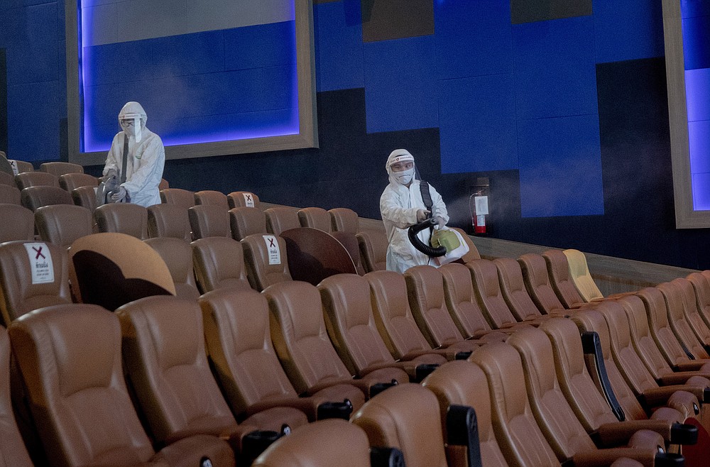 Employees spray disinfectant as a precaution against the coronavirus at the Paragon Cineplex movie theater in Bangkok, Thailand, Monday, June 1, 2020. Thai authorities allowed movie theater and other businesses to reopen, selectively easing restrictions against the coronavirus. (AP Photo/Sakchai Lalit)