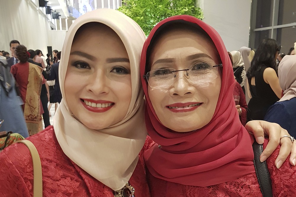 In this photo released by Eva Rahmi family, Rahmi and her mother Ismy Latifah, right, pose for a photo in Jakarta, Indonesia, Jan 28, 2018. Jan 28, 2018. Salama worries that authorities in Jakarta, Indonesia’s sprawling capital, are acting too soon to lift restrictions put in place two months ago to fight the spread of the coronavirus. Salama has reason to be concerned. She saw firsthand the tremendous agony the virus can inflict when her mother and father both died from COVID-19 within two days of each other. (Eva Rahmi family via AP)