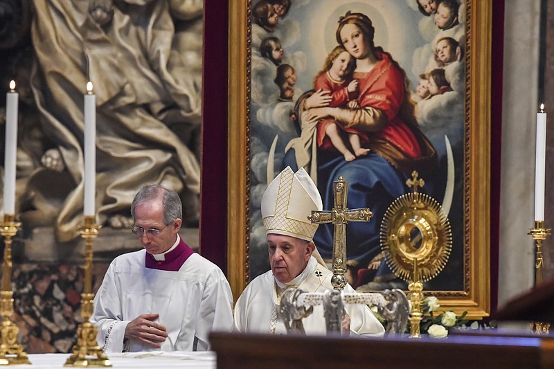 Pope Francis is flanked by Mons. Guido Marini, the Vatican master of liturgical ceremonies, left, after celebrating the Corpus Domini Mass, inside St. Peter's Basilica at the Vatican Sunday, June 14, 2020.  (Tiziana Fabi/Pool Photo via AP)