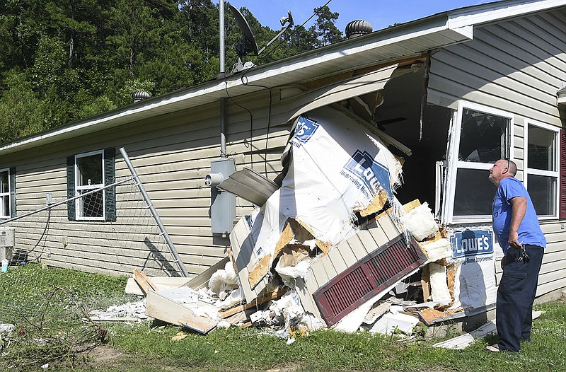 Bobby Murphree surveys the damage done to his former home at 109 Vivian St. after a hit-and-run collision Monday afternoon. - Photo by Grace Brown of The Sentinel-Record