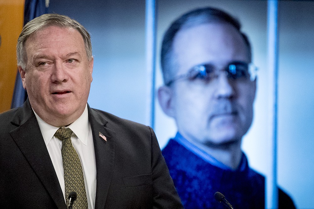 An image of Paul Whelan, a former U.S. marine who was arrested for alleged spying in Moscow, is displayed behind Secretary of State Mike Pompeo as he speaks during a news conference at the State Department in Washington, Wednesday, June 10, 2020. (AP Photo/Andrew Harnik, Pool)