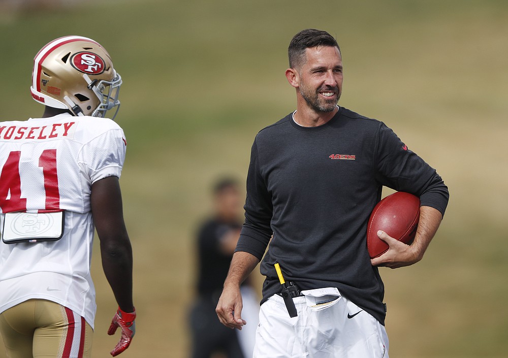 FILE - In this Aug. 16, 2019, file photo, San Francisco 49ers head coach Kyle Shanahan, right, jokes with cornerback Emmanuel Moseley during a combined NFL football training camp with the Denver Broncos at the Broncos' headquarters in Englewood, Colo. Commissioner Roger Goodell told the 32 NFL clubs on Thursday, June 4, 2020, that coaching staffs are allowed to return to team facilities starting Friday. (AP Photo/David Zalubowski, File)