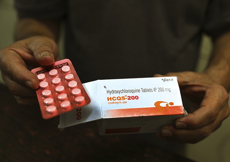 FILE - In this April 9, 2020 file photo, a chemist displays hydroxychloroquine tablets in New Delhi, India. U.S. regulators are revoking emergency authorization for malaria drugs promoted by President Donald Trump for treating COVID-19. The Food and Drug Administration said Monday, June 15 that the drugs hydroxychloroquine and chloroquine are unlikely to be effective in treating the coronavirus. (AP Photo/Manish Swarup, File)