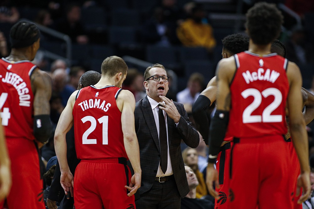 FILE - In this Jan. 8, 2020, file photo, Toronto Raptors coach Nick Nurse, center, gathers his team during a timeout in the first half of an NBA basketball game against the Charlotte Hornets in Charlotte, N.C. The Raptors have an NBA championship to defend, a very long stay at the Disney complex awaiting them and plenty of unanswered questions on how the restart of the season will work. As the NBA’s lone Canadian team, there’s an added complexity: The U.S. border. Nurse said Tuesday, June 9, 2020, that his team is still working through various scenarios for having workouts before heading to Disney World near Orlando, Florida along with 21 other teams next month for the restart of the season. (AP Photo/Nell Redmond, File)