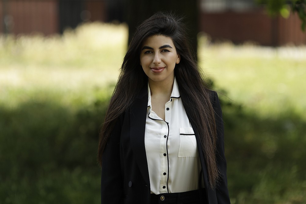 In this photo taken on Thursday, June 11, 2020, recent university graduate Sahar Shabani poses for a photograph in London. The global coronavirus crisis, which has already thrown much of the business world into turmoil, is also disrupting summer internships, which are an important stepping stone to working life for many university students and recent graduates and a recruiting pipeline for companies. Recent graduate Sahar Shabani, 22, did a three-month remote internship with a development charity based in Thailand from her parents' home in South London. (AP Photo/Matt Dunham)