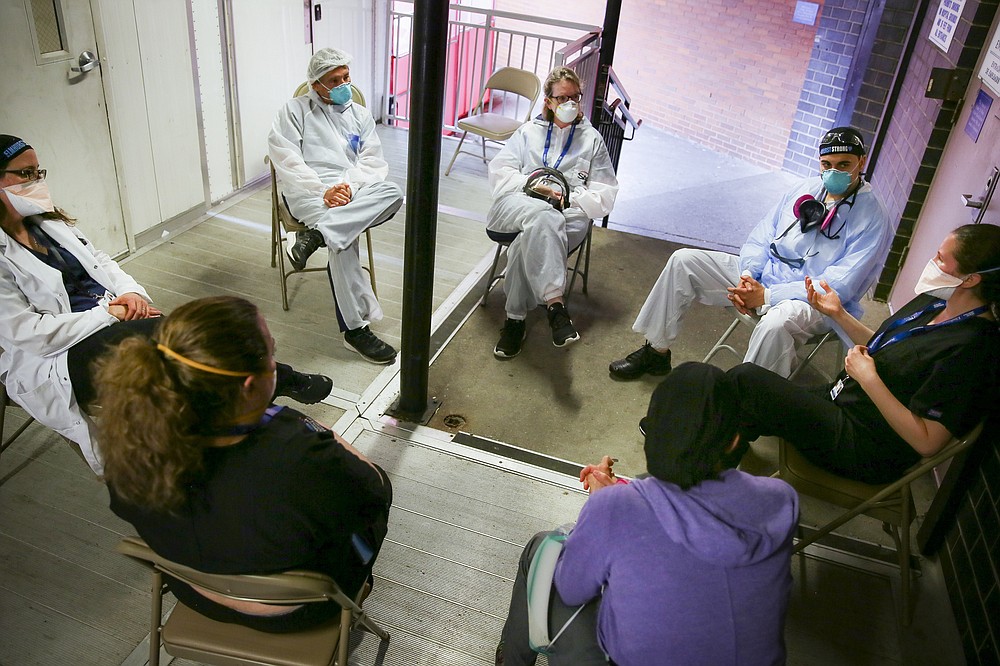 Hospital workers sit for a group counseling session at Elmhurst Hospital to talk about their experiences dealing with the COVID-19 pandemic, Friday, May 29, 2020, in New York. At hospitals around the country, nurses, doctors and other health care workers are reckoning with the psychological toll of the virus fight, coupled with fears that the disease could flare anew later this year. (AP Photo/Robert Bumsted)