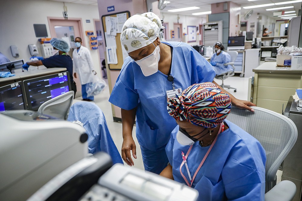 Medical personnel work in the emergency department at NYC Health + Hospitals Metropolitan, Wednesday, May 27, 2020, in New York. At hospitals around the country, nurses, doctors and other health care workers are reckoning with the psychological toll of the virus fight, coupled with fears that the disease could flare anew later this year. (AP Photo/John Minchillo)