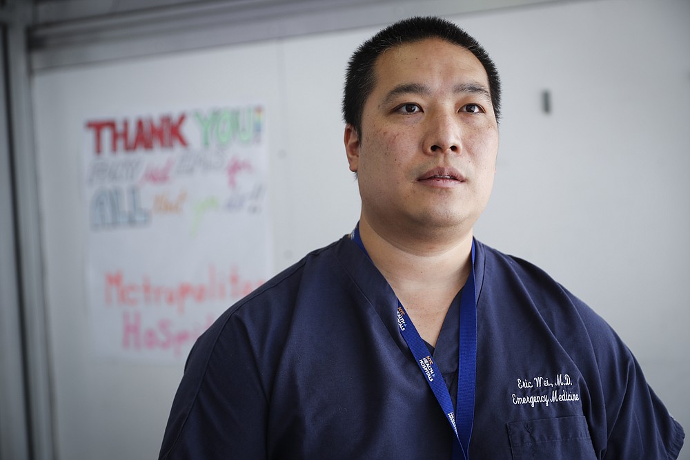 Dr. Eric Wei, vice president and chief quality officer for NYC Health + Hospitals, is interviewed outside the emergency department at NYC Health + Hospitals Metropolitan, Wednesday, May 27, 2020, in New York. At hospitals around the country, nurses, doctors and other health care workers are reckoning with the psychological toll of the virus fight, coupled with fears that the disease could flare anew later this year. (AP Photo/John Minchillo)