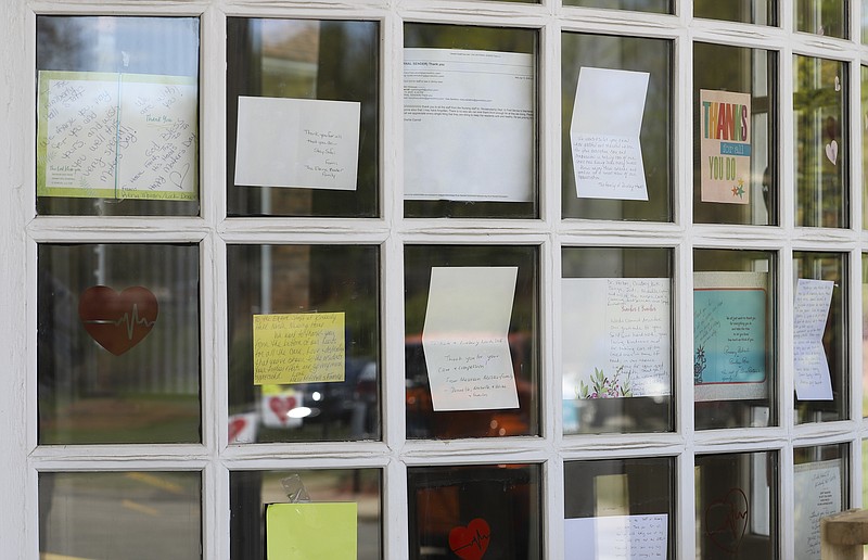 FILE - This May 14, 2020, file photo shows notes for healthcare workers taped in the front window at the Kimberly Hall North nursing home in Windsor, Conn. Nursing home residents account for nearly 1 in 10 of all the coronavirus cases in the United States and more than a quarter of the deaths, according to an Associated Press analysis of government data released Thursday, June 18. (AP Photo/Chris Ehrmann, File)