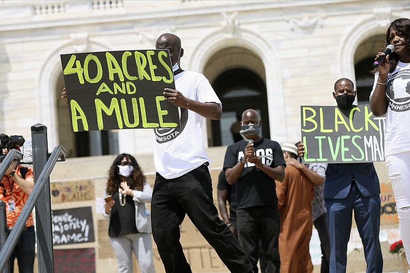 People demonstrate at the Minnesota State Capitol in St. Paul, Minn. on Friday, June 19, 2020, to mark Juneteenth. Juneteenth marks the day in 1865 when federal troops arrived in Galveston, Texas, to take control of the state and ensure all enslaved people be freed, more than two years after the Emancipation Proclamation.AP Photo/Jim Mone)