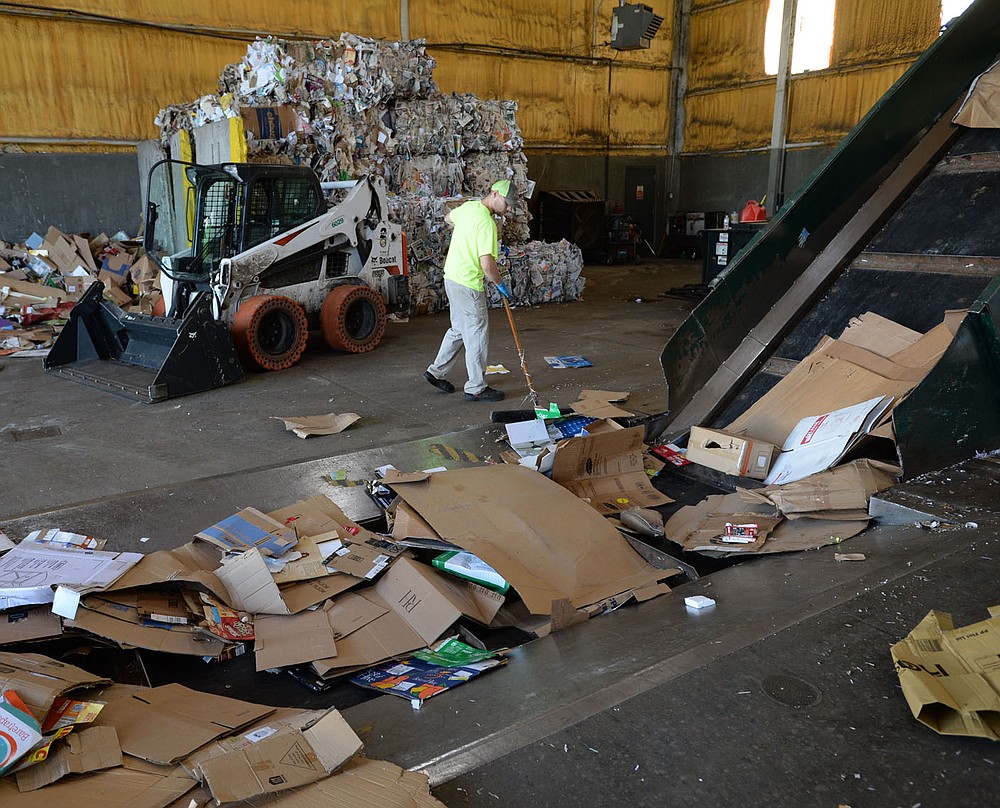 Christopher Richardson, a worker with the city of Fayetteville's Recycling and Trash Collection Division, sweeps boxes that fell from a skid steer loader Friday, June 19, 2020, while loading corrugated cardboard into a baling machine at the division's facility. Recycling collection during suspension of the curbside program was about 79% of what it was from March to June last year. The city’s curbside service resumes Monday.Visit nwaonline.com/200621Daily/ for today's photo gallery.
(NWA Democrat-Gazette/Andy Shupe)