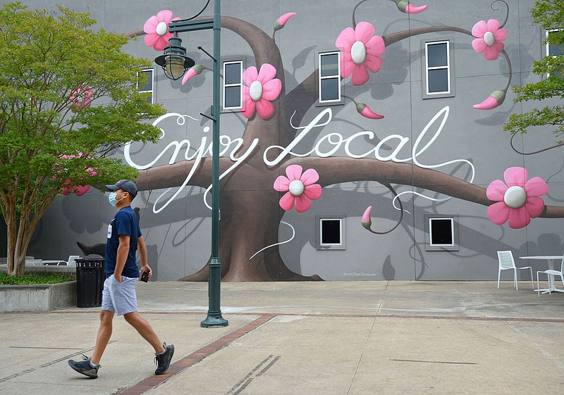 A resident walks Wednesday, June 10, 2020, past a mural painted by local artist Jason Jones near the Fayetteville Town Center in downtown. Visit nwaonline.com/200614Daily/ for today's photo gallery.
(NWA Democrat-Gazette/Andy Shupe)