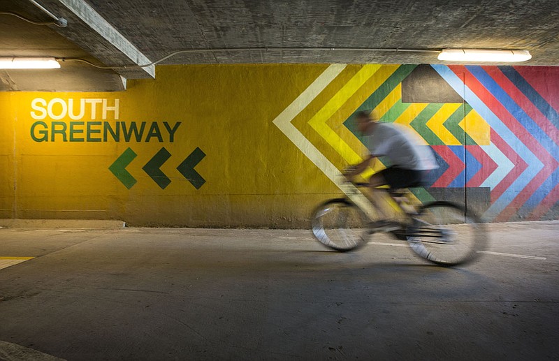 A cyclist rides past a wayfinding mural Saturday, June 13, 2020, inside the Razorback Regional Greenway tunnel at the intersection of Southeast J Street and Southeast 8th Street in Bentonville. The mural was painted in 2018 by Graham Edwards of Bella Vista and features directional guidance for trail users. Go to nwaonline.com/200614Daily/ to see more photos.
(NWA Democrat-Gazette/Ben Goff)