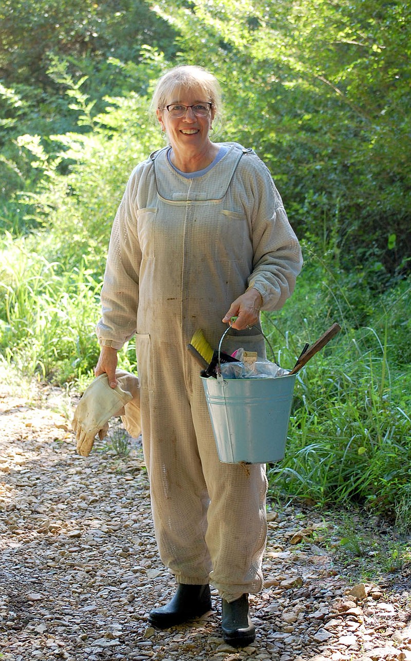 Janelle Jessen/Herald-Leader
Lynn Paskiewicz walks down the hill to the meadow to care for her bees.