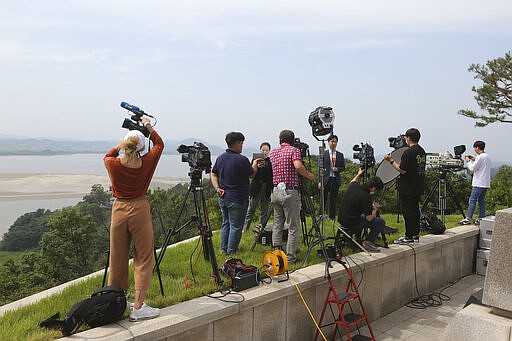 Journalists take video footage from the unification observation post in Paju, South Korea, near the border with North Korea, Wednesday, June 17, 2020. North Korea said Wednesday it will redeploy troops to now-shuttered inter-Korean cooperation sites, reinstall guard posts and resume military exercises at front-line areas, nullifying the tension-reducing deals reached with South Korea just two years ago. (AP Photo/Ahn Young-joon)