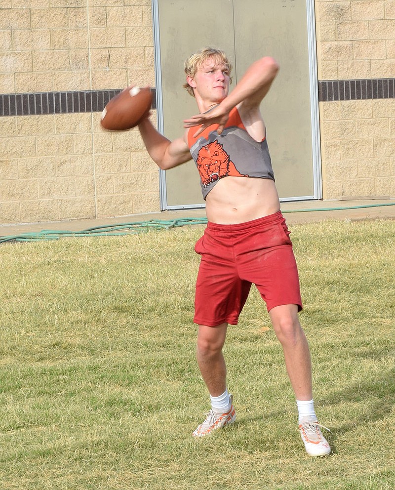 Westside Eagle Observer/MIKE ECKELS

Senior quarterback Cy Hilger draws back the ball just before releasing a throw to Coach Kelby Bohannon during the Lions senior high football practice in Gravette June 23. Like all high school sports teams around the state, the Lions were required to hold a light practice session and no contact exercises.