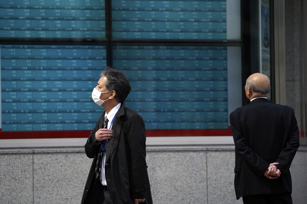 A man looks at an electronic stock board showing Japan's Nikkei 225 index at a securities firm in Tokyo March 13, 2020. Asian shares were mostly higher on Tuesday, June 23, 2020, tracking a late rally on Wall Street led by technology shares. (AP Photo/Eugene Hoshiko)