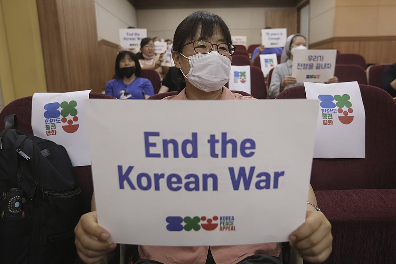 An anti-war activist holds a card during a press conference to demand the peace on the Korean peninsula on the eve of the 70th anniversary of the outbreak of the Korean War in Seoul, South Korea, Wednesday, June 24, 2020. North Korean leader Kim Jong Un suspended his military's plans to take unspecified retaliatory action against South Korea, state media said Wednesday, possibly slowing a pressure campaign against its rival amid stalled nuclear negotiations with the Trump administration. (AP Photo/Ahn Young-joon)