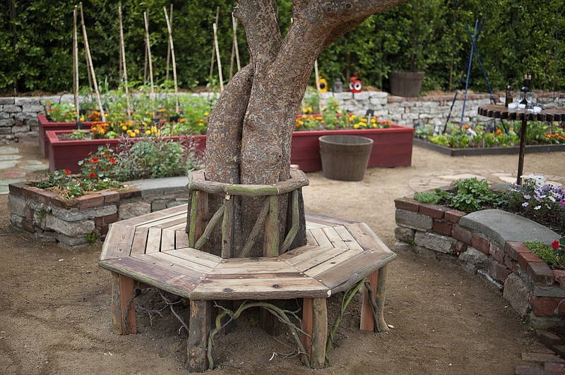 In this 2011 photo provided Martha Benedict, a bench around a tree and raised flower and vegetable beds, all built by landscape designer Katharine Pinney from discarded scaffolding, are shown in a kitchen garden at a home in La Canada, Calif. Homeowners can transform an ordinary looking landscape with some imagination, design, and perhaps the help of a local agriculture extension service, landscape professional or private nursery. (Martha Benedict/Katharine Pinney via AP) story.lead_photo.caption