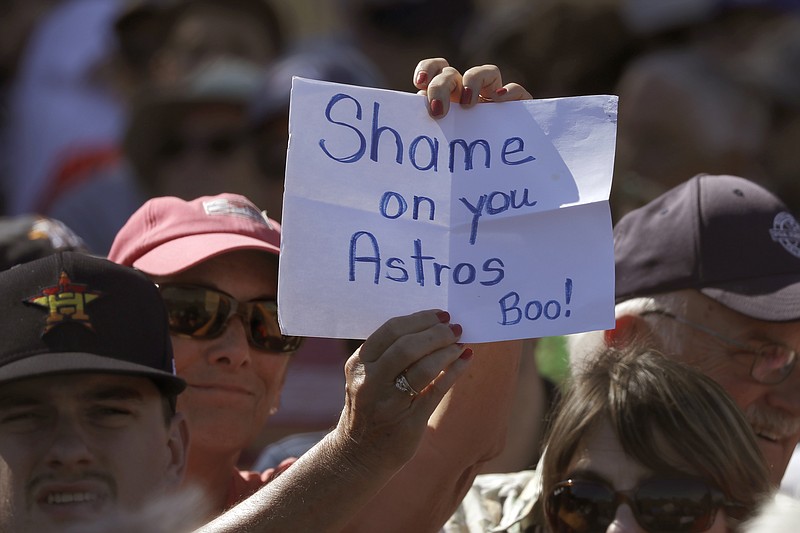 A fan holds a sign during a spring training baseball game between the Houston Astros and the Washington Nationals Sunday, Feb. 23, 2020, in West Palm Beach, Fla. (AP Photo/John Bazemore)