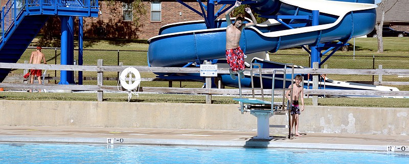 Marc Hayot/Siloam Sunday A kid dives off the diving board as another looks on a the Family Aquatic Center. The Family Aquatic Center opened June 18 and is open from 1 p.m. to 7 p.m. Monday through Saturday and 2 p.m. to 6 p.m. on Sunday, according to City Administrator Phillip Patterson. The regular pool and slides are open although the baby pool is closed due to the coronavirus. Tables and chairs have been spaced out for social distancing and the maximum occupancy has dropped from 300 to 125 per health department directives, Patterson said.