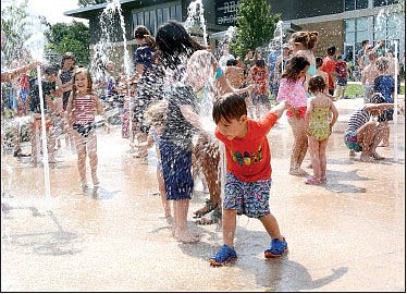 Janelle Jessen/Siloam Sunday Children playing in the splash pad at Memorial Park during the park's grand opening in May of 2019.