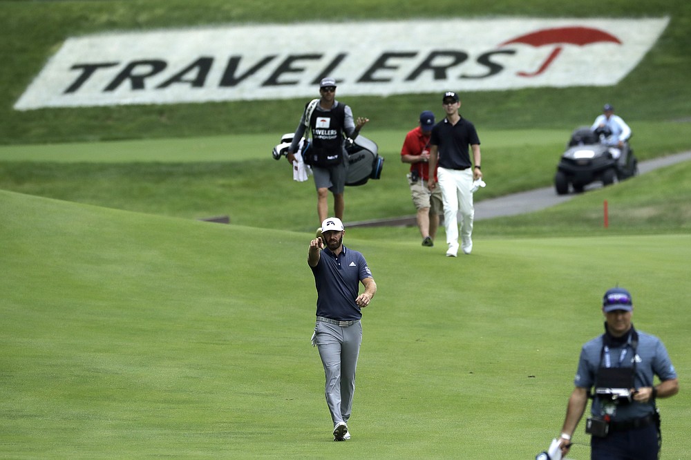 Dustin Johnson, center, gestures as he walks toward his ball on the 15th fairway during the third round of the Travelers Championship golf tournament at TPC River Highlands, Saturday, June 27, 2020, in Cromwell, Conn. (AP Photo/Frank Franklin II)