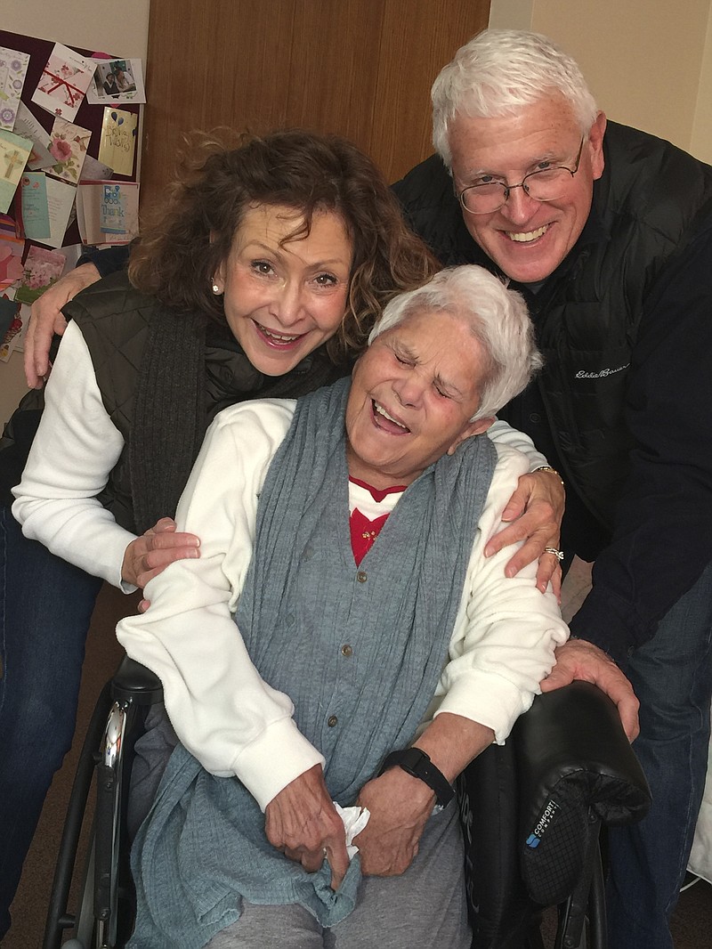 This Dec. 2017 photo provided by Julie Griffith shows Julie Griffith, left, with her mother Mabel Porter, center, and Griffith's husband, David, as they pose for a photo at a nursing home in Oregon, Ohio. The Griffiths are among those advocating to allow cameras inside long-term care facilities. Visitation bans at nursing homes because of the coronavirus have sparked renewed interest in legislation to allow the cameras.(Julie Griffith/Julie Griffith via AP) story.lead_photo.caption
