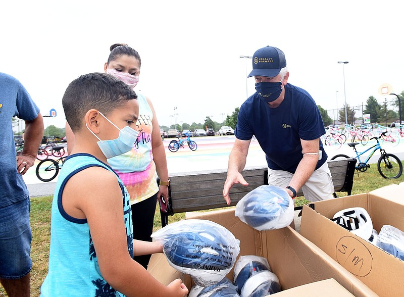 FREE WHEELING GIVEAWAY
Anthoney (cq) Roman, 6, and his mom, Narda Roman of Pea Ridge, pick out a bicycle helmet Saturday June 26 202 with help from Don Butcher, program director of Pedal it Forward. The Bentonville Fraternal Order of Police and Pedal It Forward teamed up  at Memorial Park in Bentonville to give away 150 bicycles to any youngster who needs a bike. Each child received a free helmet with their bike. Pedal It Forward volunteers collect, restore and distribute bicycles to riders of all ages. The group was founded in 2014 by area cyclists. Go to nwaonline.com/200628Daily/ to see more photos.
(NWA Democrat-Gazette/Flip Putthoff)