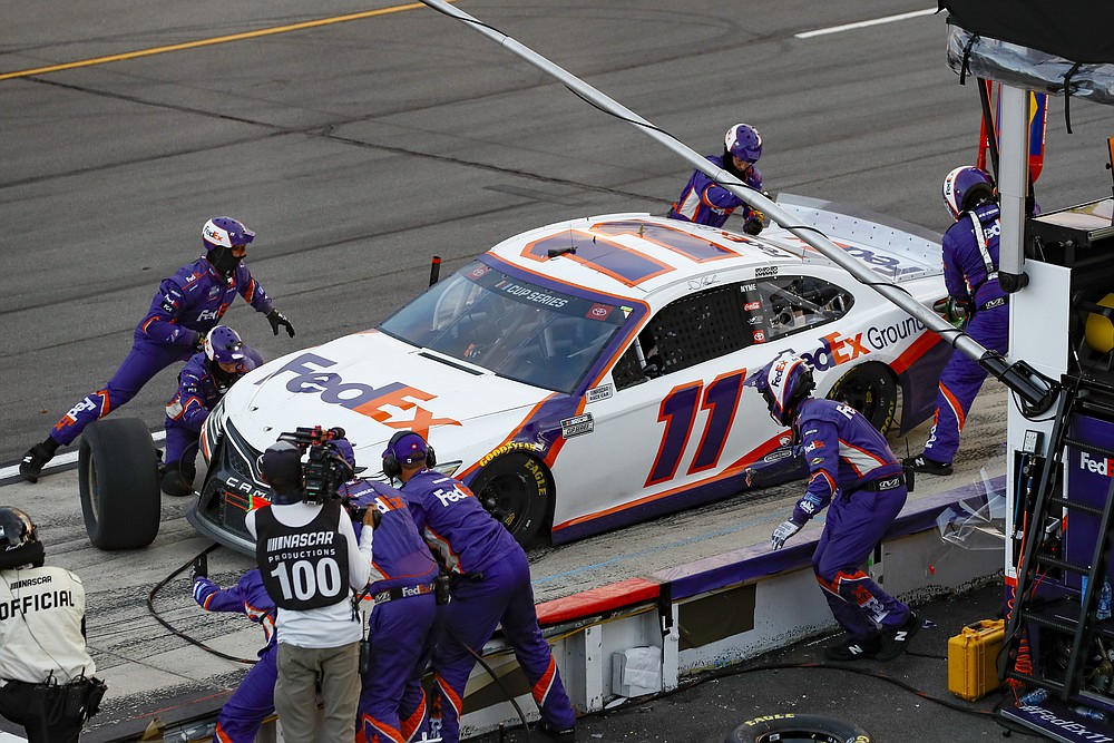 Denny Hamlin's pit crew performs a late pit stop during a NASCAR Cup Series auto race at Pocono Raceway, Sunday, June 28, 2020, in Long Pond, Pa. (AP Photo/Matt Slocum)