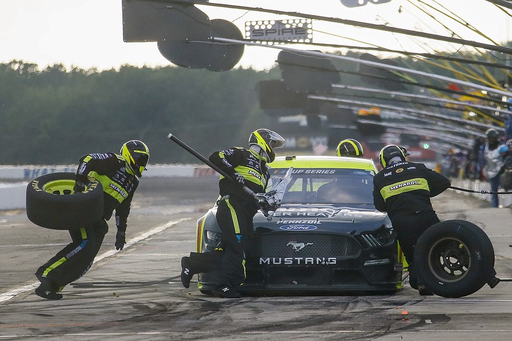 Crew members for Ryan Blaney scramble around the car in a pit stop during a NASCAR Cup Series auto race at Pocono Raceway, Sunday, June 28, 2020, in Long Pond, Pa. (AP Photo/Matt Slocum)