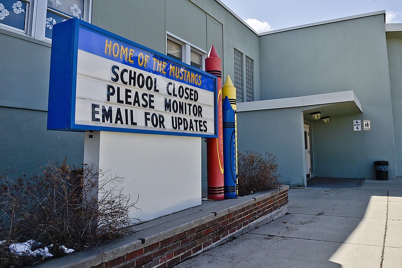FILE - This Thursday, April 16, 2020 file photo shows a sign announcing an elementary school in Helena, Mont., is closed. When the coronavirus pandemic took hold across the United States in mid-March, forcing schools to close and many children to be locked down in households buffeted by job losses and other forms of stress, many child-welfare experts warned of a likely surge of child abuse. Fifteen weeks later, the worries persist — yet some experts on the front lines, including pediatricians who helped sound the alarm, say they’ve seen no evidence yet that a marked increase has taken place. (Thom Bridge/Independent Record via AP) story.lead_photo.caption