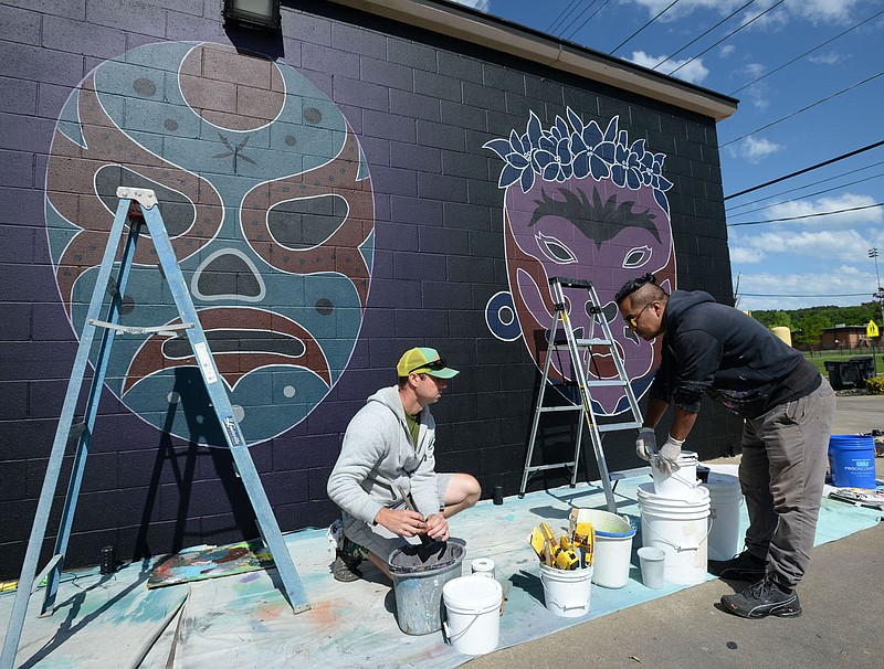 Artists Jason Jones (left) and Octavio Logo discuss Wednesday, May 6, 2020, their plan while working on a mural at Mangos Gourmet Taco Shop at 2050 W. Martin Luther King Jr. Boulevard in Fayetteville. The mural features three lucha libre masks that will appear to glow with a mist of fluorescent color. Visit nwaonline.com/200507Daily/ for today's photo gallery.
(NWA Democrat-Gazette/Andy Shupe)