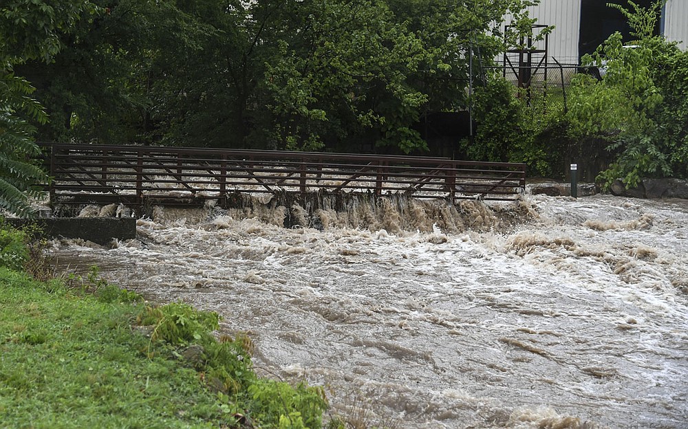 Hot Springs Creek rushes over a bridge behind the Valley Street Skatepark on Monday. - Photo by Grace Brown of The Sentinel-Record