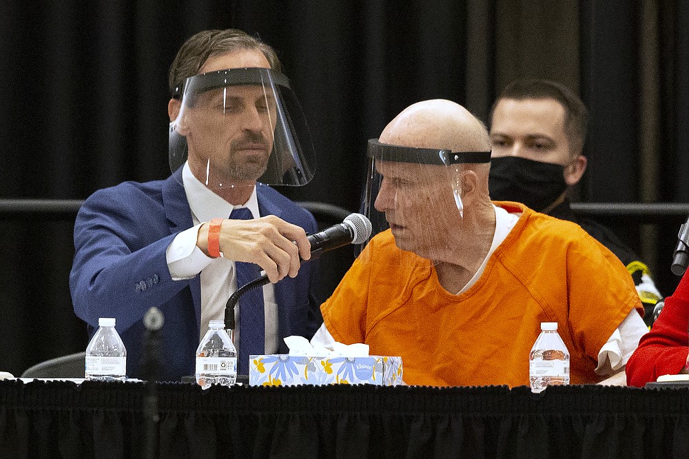 Joseph Cress, left, the public defender for Joseph James DeAngelo, charged with being the Golden State Killer, adjusts the microphone for his client during a hearing in Sacramento Superior Court in Sacramento, Calif. Monday June 29, 2020. DeAngelo, 74, pleaded guilty to 13 counts of murder and multiple other charges 40 years after a sadistic series of assaults and slayings in California. Due to the large numbers of people attending, the hearing was held at a ballroom at California State University, Sacramento to allow for social distancing. (AP Photo/Rich Pedroncelli)