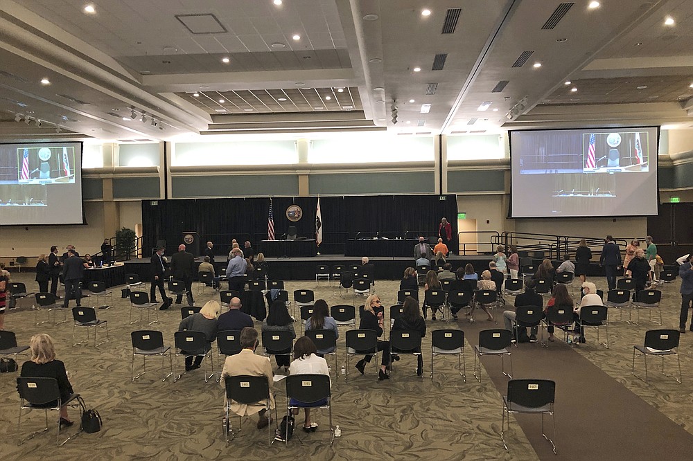 People gather in a courtroom set up in a ballroom where a 74-year-old former police officer is tentatively set to plead guilty Monday, June 29, 2020, to being the elusive Golden State Killer in Sacramento, Calif. The hearing comes 40 years after a sadistic suburban rapist terrorized California in what investigators only later realized were a series of linked assaults and slayings. The plea deal will spare Joseph DeAngelo any chance of the death penalty, but in partial return survivors of the assaults that spanned the 1970s and 1980s expect him to admit to dozens of rapes that could not be criminally charged because too much time has elapsed. (AP Photo/Rich Pedroncelli)